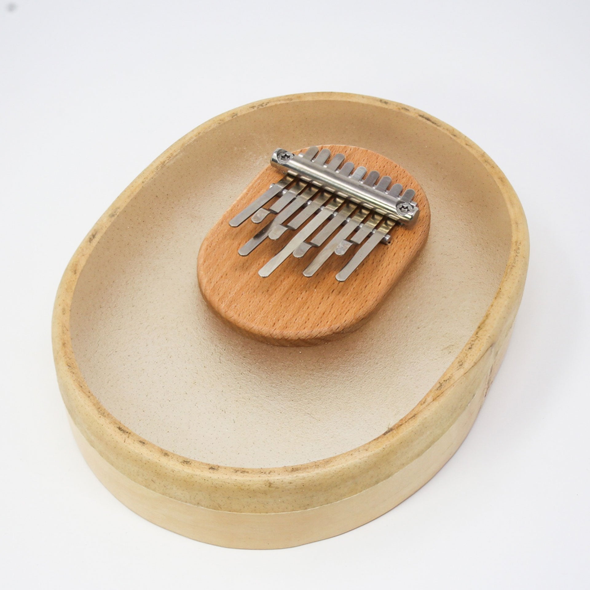 Second view of transparent 8+1 note kalimba with calf-skin bowl and wooden bridge on white background