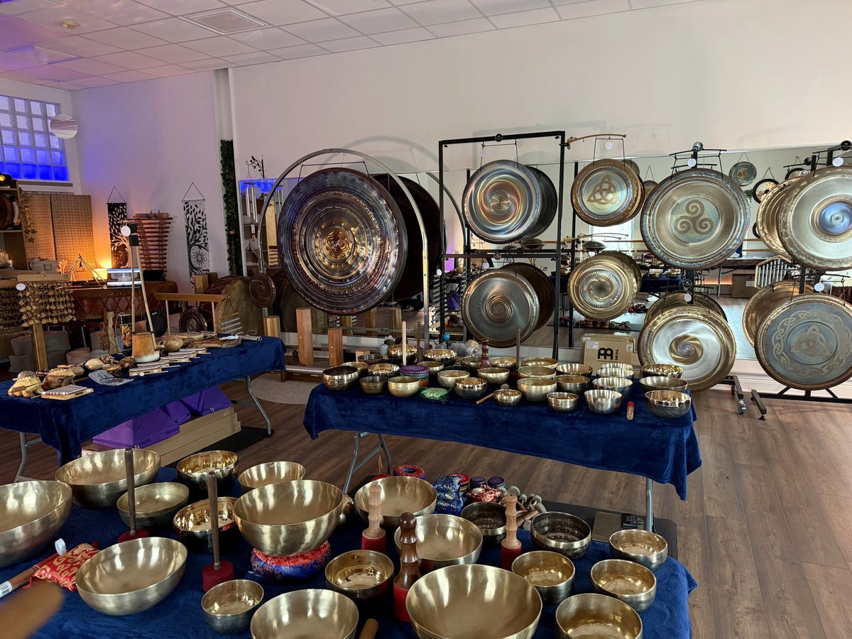 Tables of singing bowls and a wall of gongs in the Revival Harmony showroom