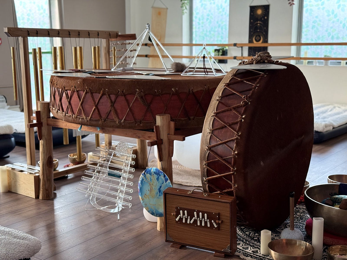 A large drum, crystal pyramids and other instruments set up for a sound bath