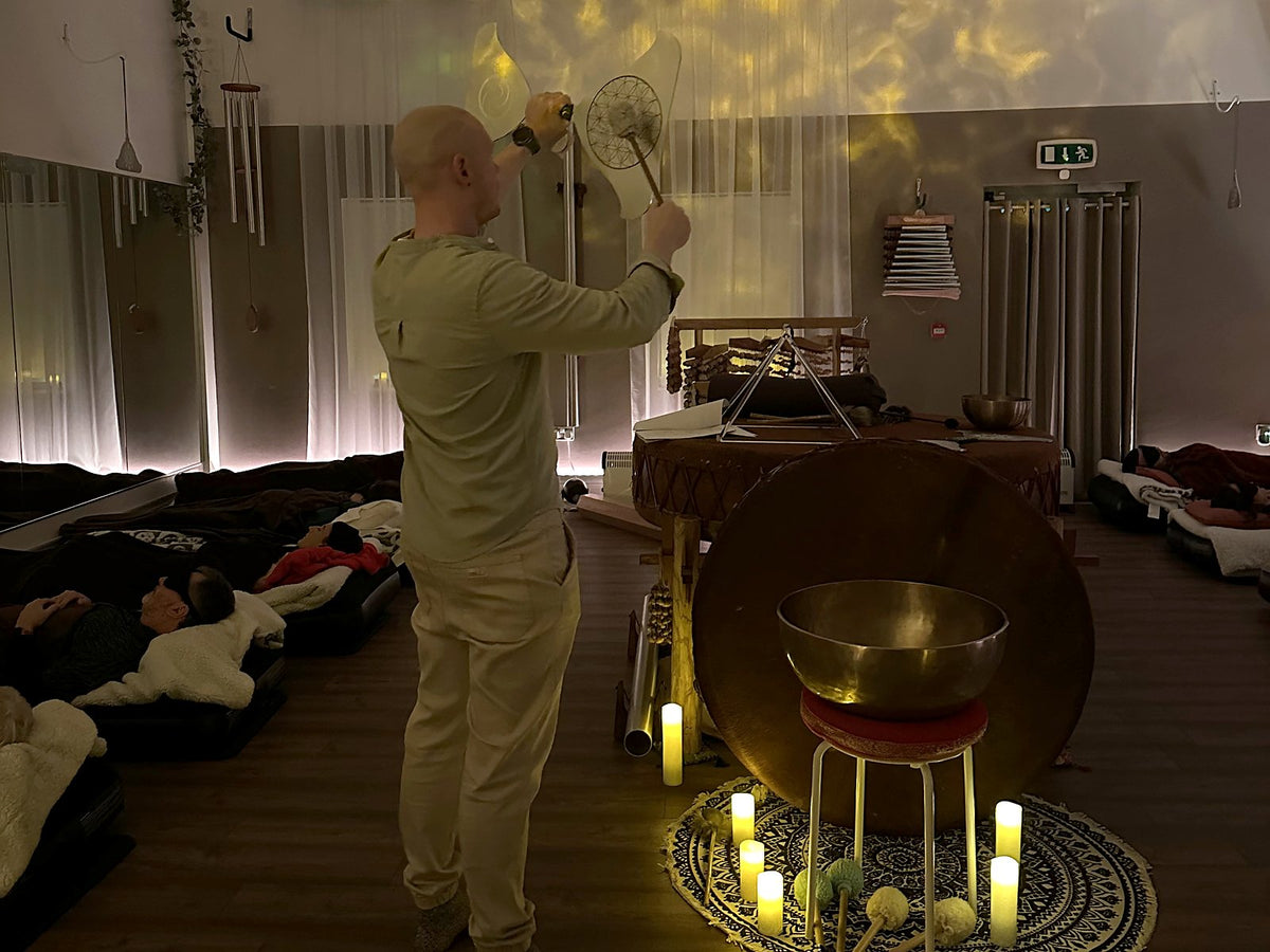 Éanna playing during an evening sound bath while people rest under blankets