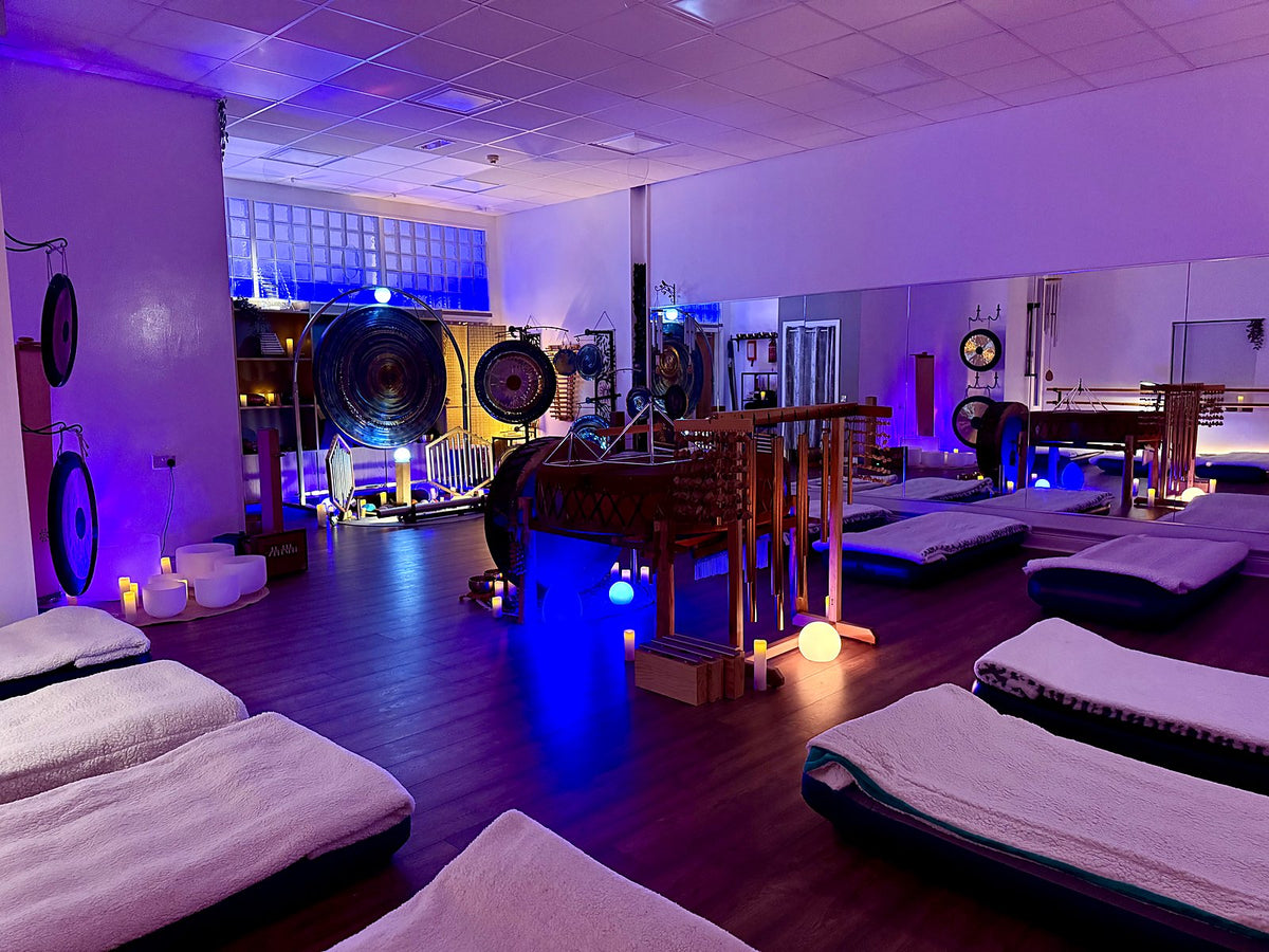 The studio set for a sound bath, with rows of air beds and blankets facing the instruments