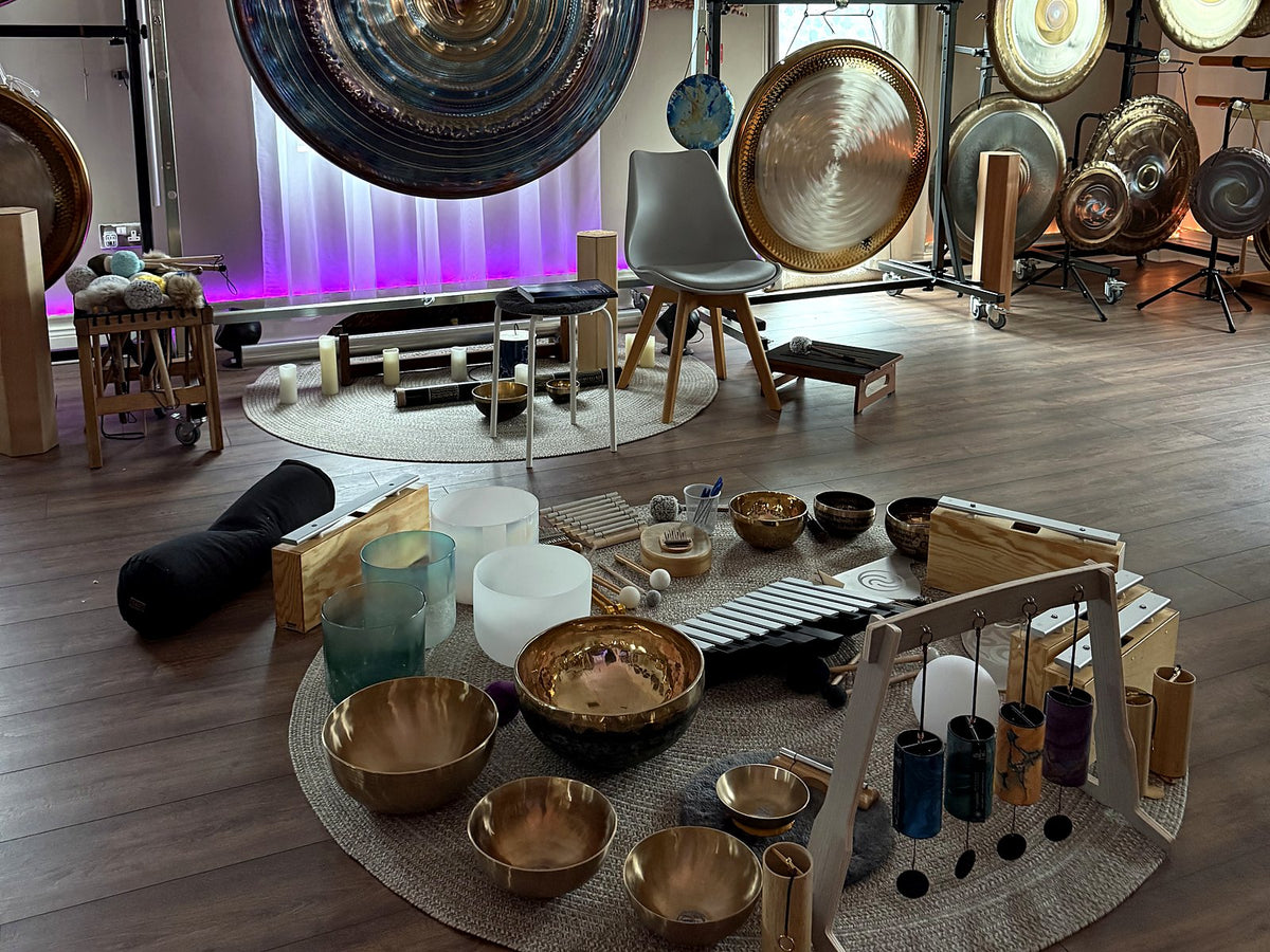 Gongs, singing bowls and chimes laid out for a sound bath