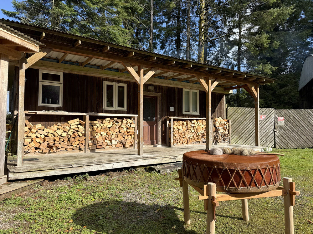 A large hide drum on a stand in front of a cabin at Hollyford