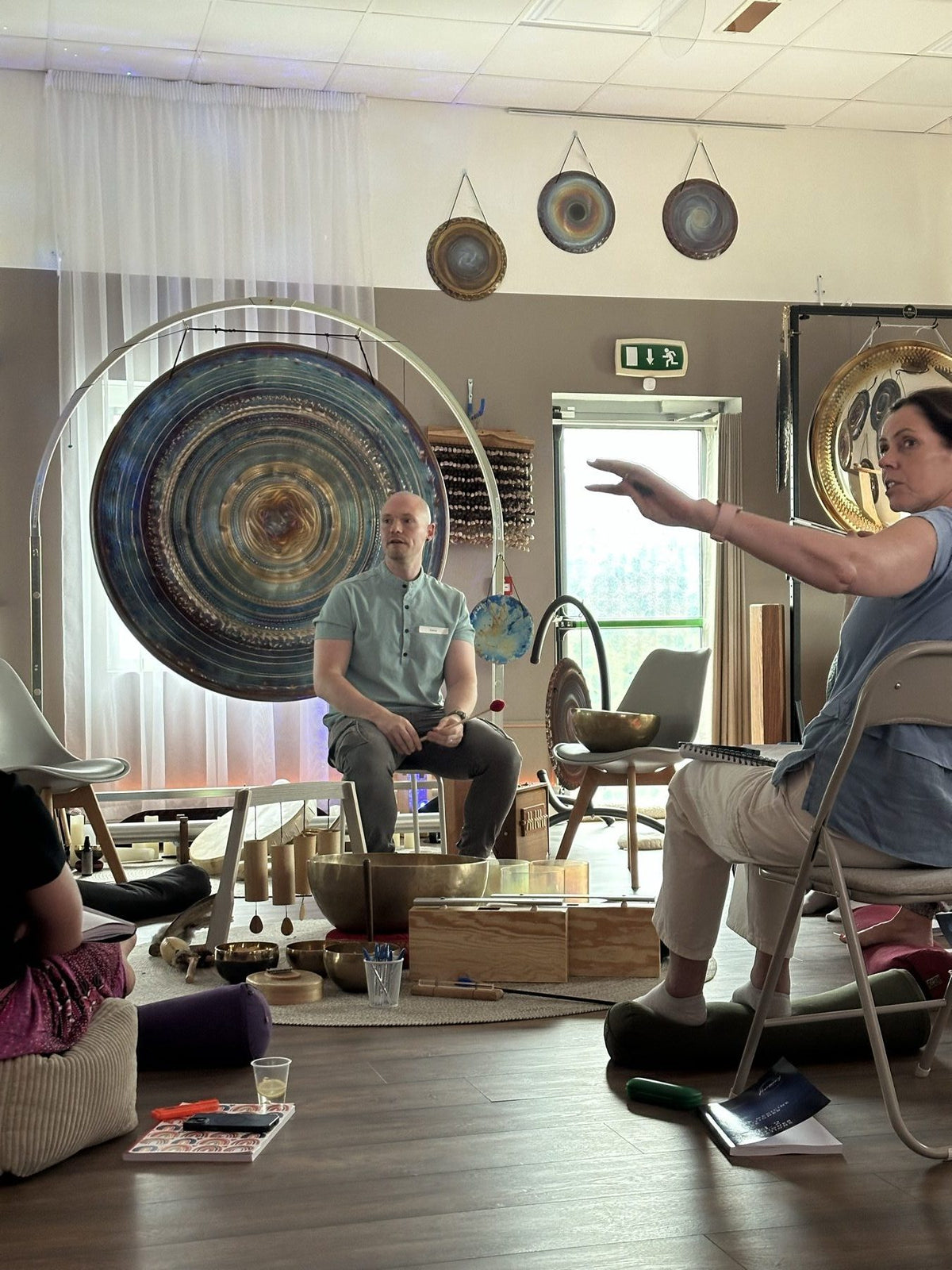 Students and tutor discussing sound healing in the Revival Harmony studio
