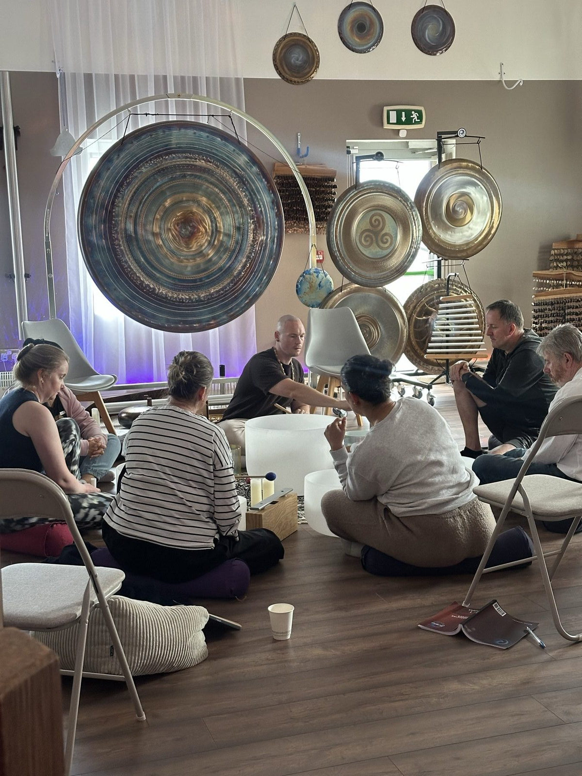 A small group learning together among gongs and singing bowls